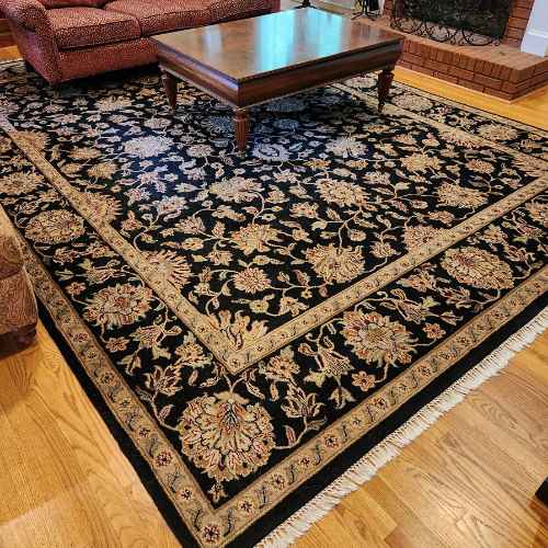 black oriental rug on top of hardwood floor in living room