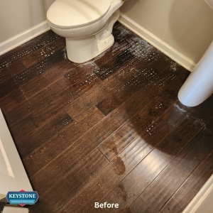 brown engineered hardwood floor in a bathroom with stains on the wood