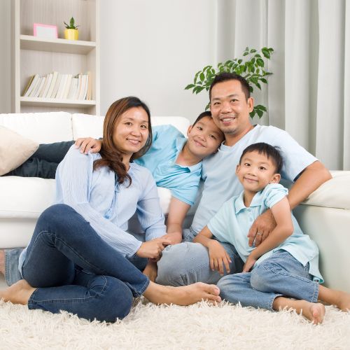 nice family posing and smiling sitting on clean carpet