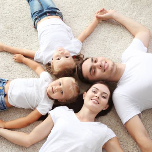 happy family laying on clean white carpeting in a circle