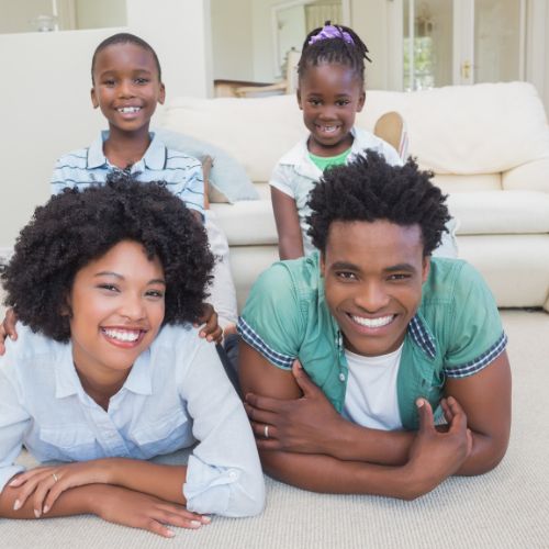 family of four on freshly cleaned carpet smiling for picture